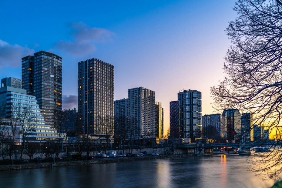 Stunning Paris skyline featuring modern skyscrapers by the river during sunset.